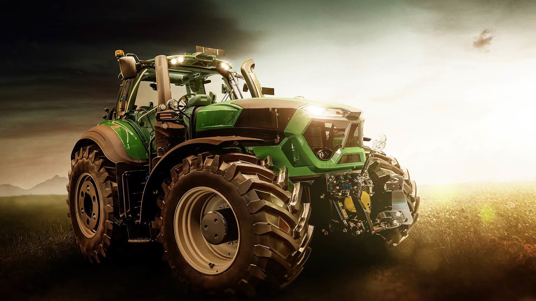 Traktor im Feldeinsatz bei Sonnenuntergang